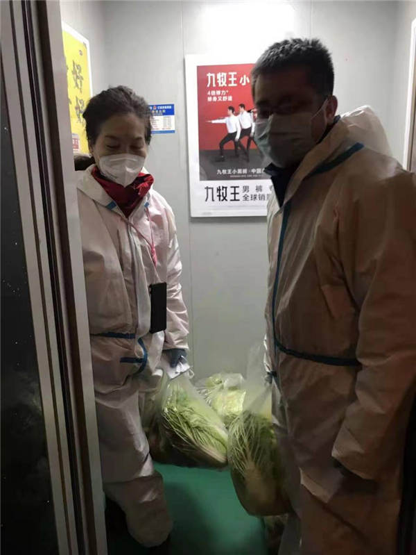 趙亮配合社區工作者為居民發放菜品.png